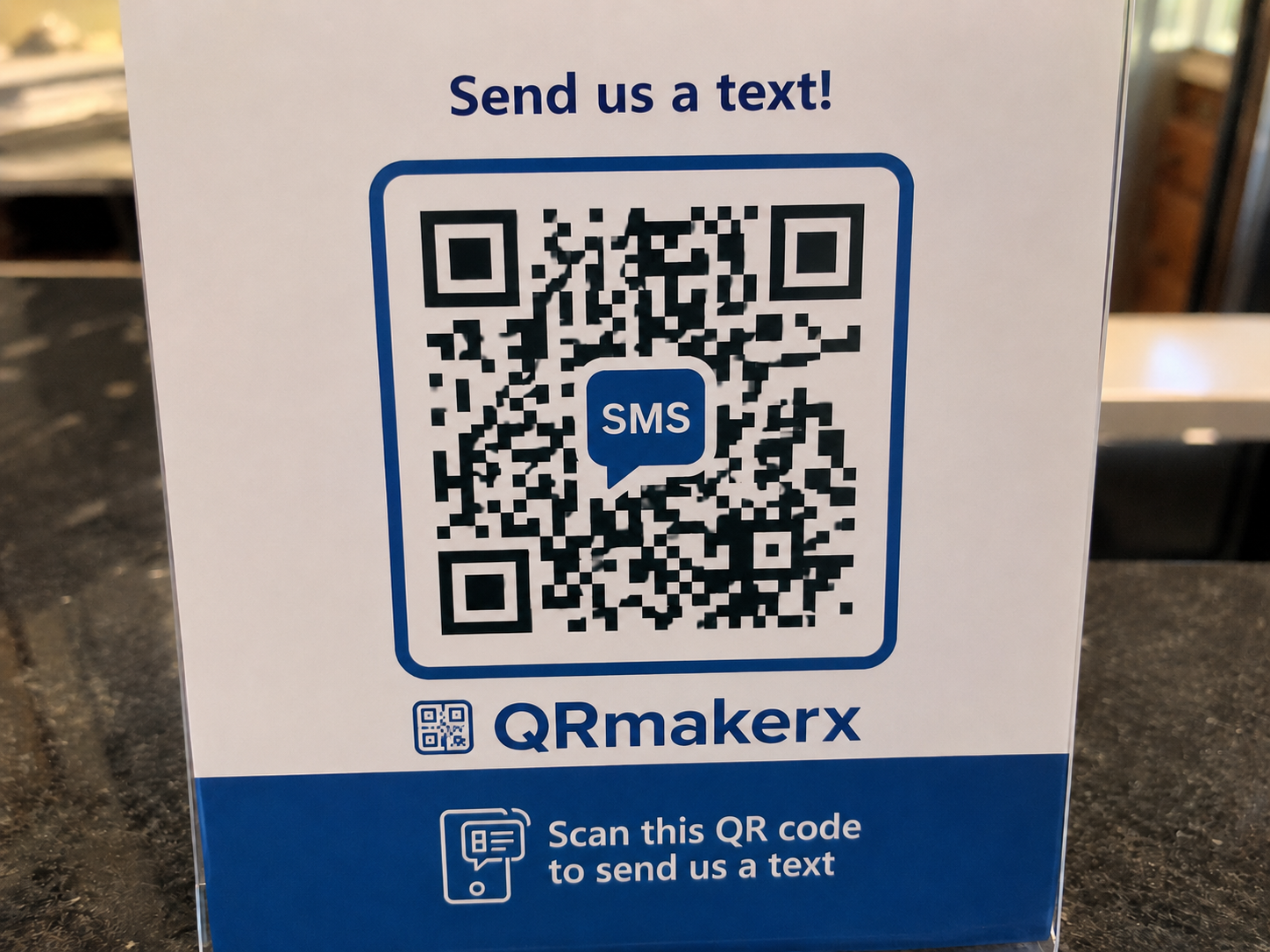 Real-life SMS QR code displayed on a countertop sign that opens a prefilled text message when scanned